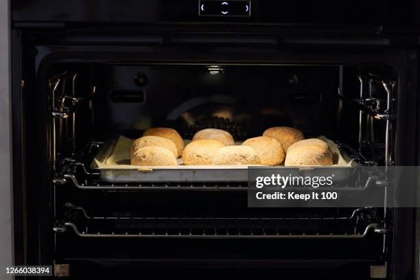 home made wholemeal rolls baking in the oven - kitchen front view stock pictures, royalty-free photos & images