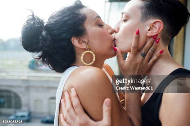 lesbian couple kissing in balcony - lesbians kissing stock pictures, royalty-free photos & images