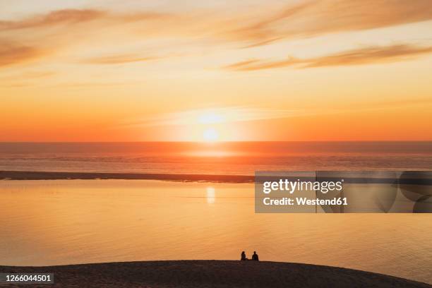 silhouette couple watching sunset at atlantic ocean, dune of pilat, nouvelle-aquitaine, france - duna de pilat fotografías e imágenes de stock