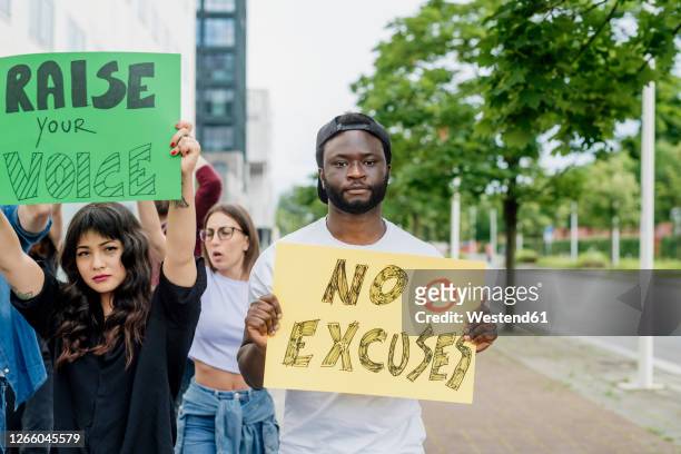 multi ethnic activists protesting on street in city - activist stock pictures, royalty-free photos & images