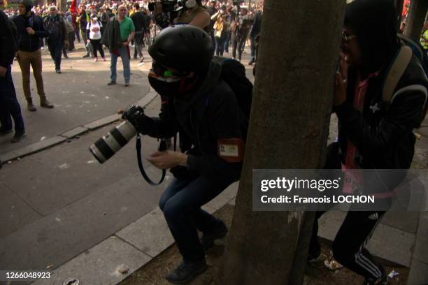 Photojournaliste essayant de se protéger lors de la manifestation du 1er mai 2019, Paris, France.