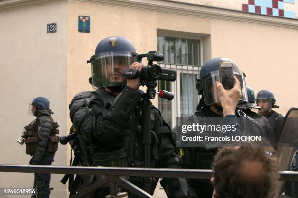 Gendarme mobile avec une caméra et manifestant filmant avec son téléphone portable lors de la manifestation du 1er mai 2019, Paris, France.
