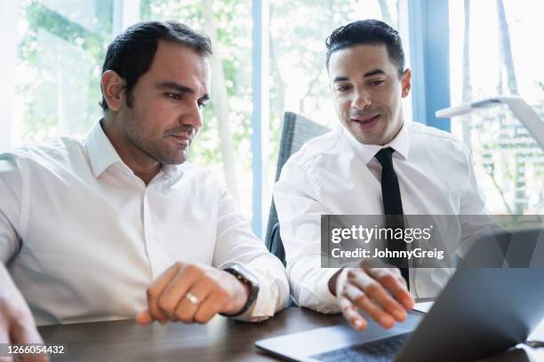 male hispanic business colleagues discussing data on laptop - business talk stock pictures, royalty-free photos & images