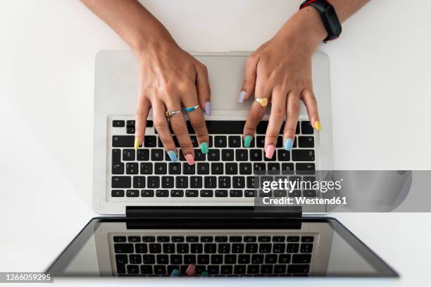 close-up of woman hands using laptop on table at home - raised finger stock-fotos und bilder