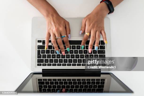 close-up of woman hands using laptop on table at home - multi coloured nails stock pictures, royalty-free photos & images