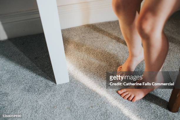 child's feet on grey thick pile carpet, casting shadow - nylon feet stock-fotos und bilder