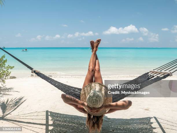jovem tomando sol em praia tropical, pés para cima - feet up - fotografias e filmes do acervo