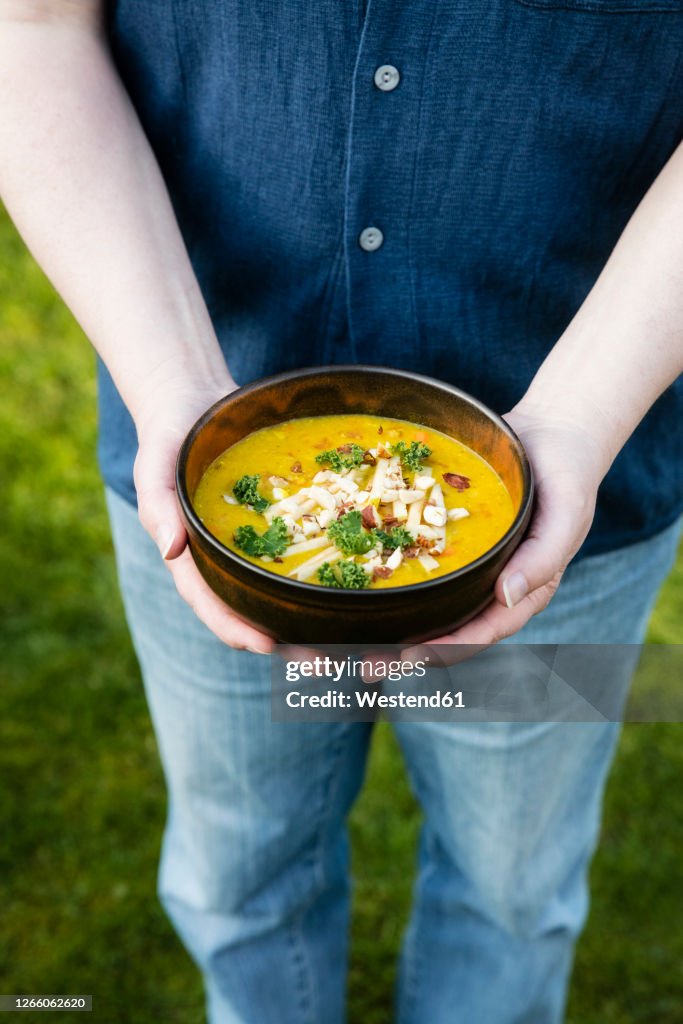 Mans hands holding bowl withdalof lentils, potatoes and vegetables