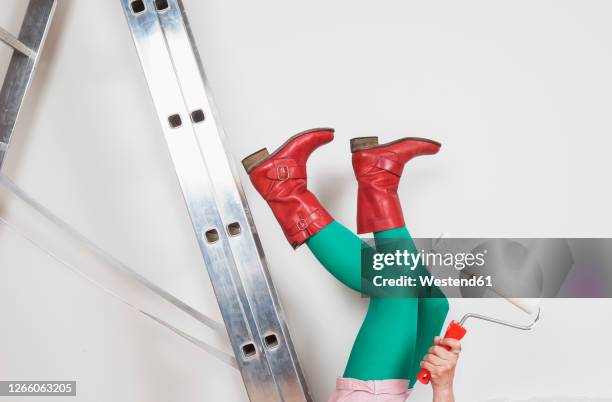 woman falling from step ladder during painting walls at home - stocking feet fotografías e imágenes de stock