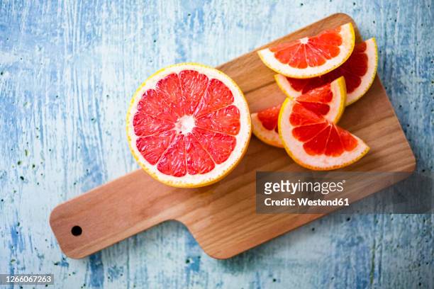 fresh grapefruit on chopping board - grapefruit red - fotografias e filmes do acervo