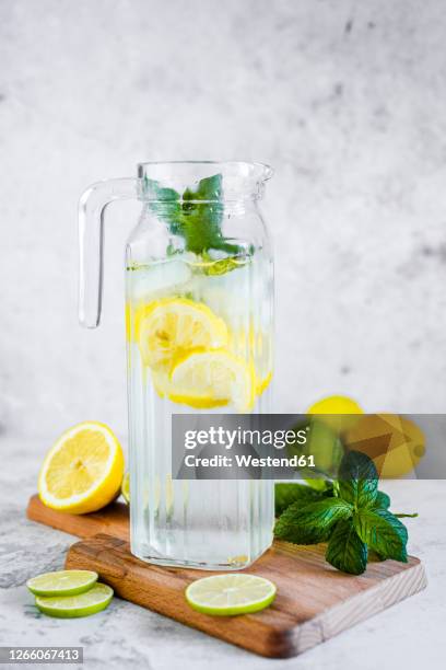 detox water with lemon, lime and mint and ice cubes - carafe stock pictures, royalty-free photos & images
