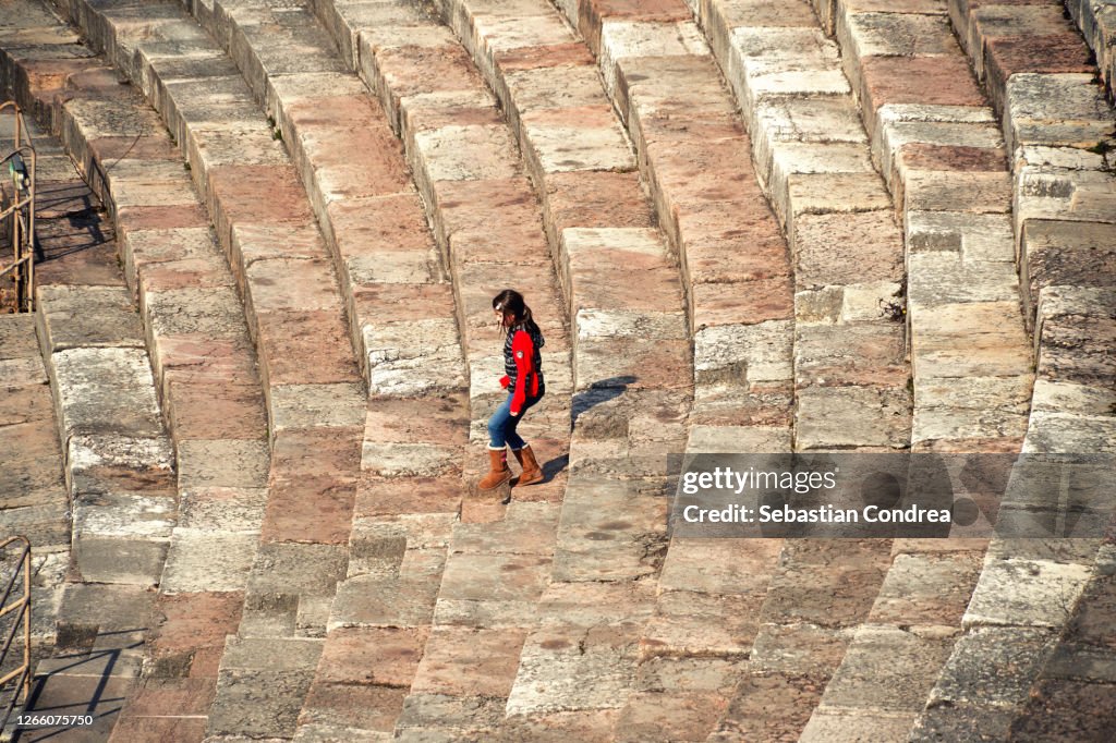 Girl descending the steps of the second largest Roman arena in Verona, Italy