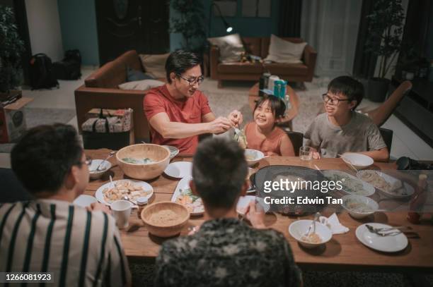 eine asiatische chinesische familien und freunde beim abendessen treffen zu hause mit traditionellen chinesischen dampfschiff-gerichte - chinese family dinner stock-fotos und bilder