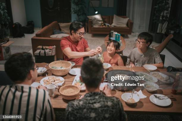 una familia china asiática y amigos que tienen cena nocturna reunidos en casa con platos tradicionales de vapor chinos - hot pot dish fotografías e imágenes de stock