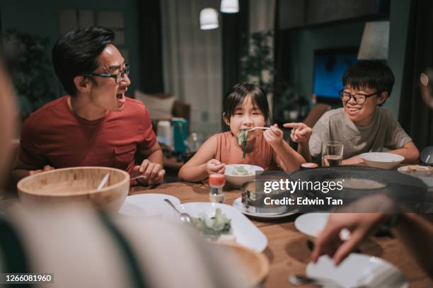 an asian chinese families and friends having night dinner gathering at home with traditional chinese steamboat dishes - chinese family eating stock pictures, royalty-free photos & images