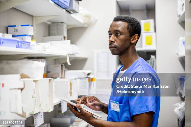 病院で医療用品の在庫を行う若い医師 - medical supplies ストックフォトと画像
