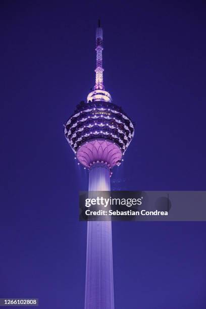 misty night over city skyline with kuala lumpur tower. - menara kuala lumpur tower stockfoto's en -beelden