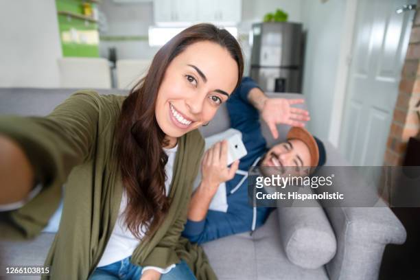 happy couple at home on a video call and waving to the camera - introducing boyfriend stock pictures, royalty-free photos & images