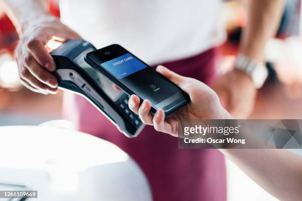 paying with mobile phone at restaurant - credit card stock-fotos und bilder