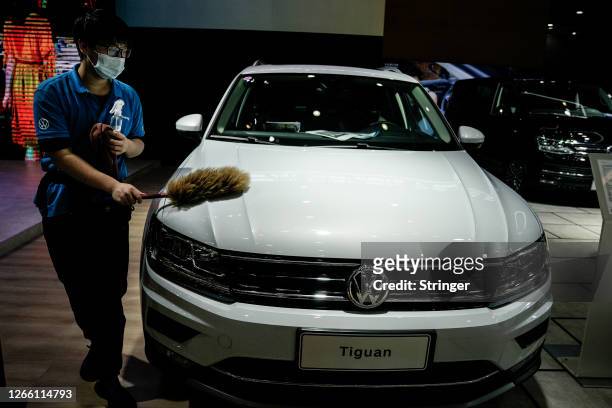 Staff member wears a protective mask while cleaning a Volkswagen booth at the 18th Central China International Auto Show on August 13, 2020 in Wuhan,...