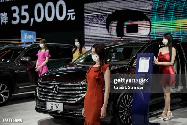 Models wear masks as a precaution as they display Volkswagen models during the 18th Central China International Auto Show on August 13, 2020 in...