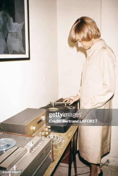 Françoise Sagan met un disque vinyle chez elle à Paris en novembre 1975, France