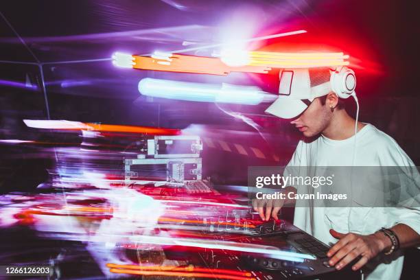 portrait of confident young dj with headphones - dj stockfoto's en -beelden