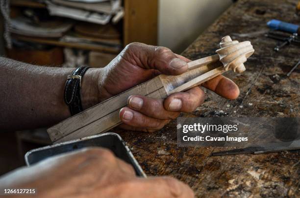 violin maker luthier hand working a new violin scroll in cremona italy - instrument maker stock pictures, royalty-free photos & images