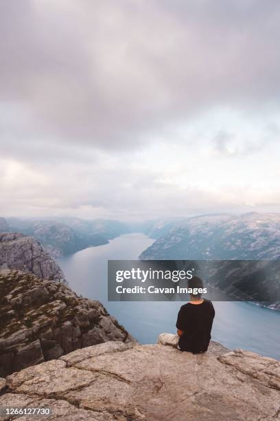 man sitting in rock at edge of cliff at preikestolen, norway - 101628 stock pictures, royalty-free photos & images