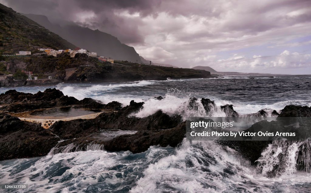Waves breaking against the rock over the natural pools in Garachico in Tenerife Island