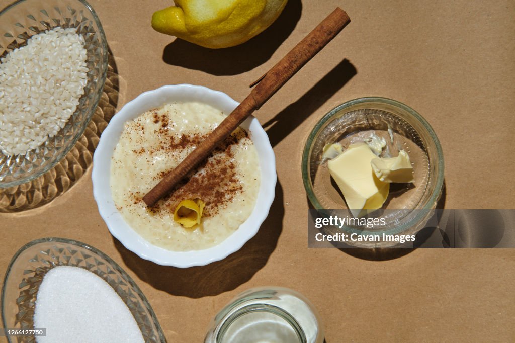 Rice pudding with its ingredients on a brown background