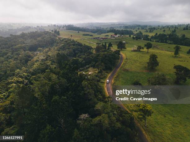 aerial shot driving through millaa millaa town sourrandings in monsoon season at tropical queensland, australia - atherton tableland stock pictures, royalty-free photos & images