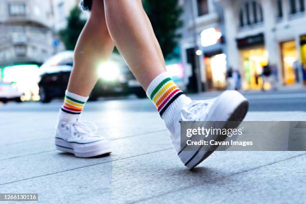 woman's legs walking down the street with a car in the background - schuhwerk stock-fotos und bilder