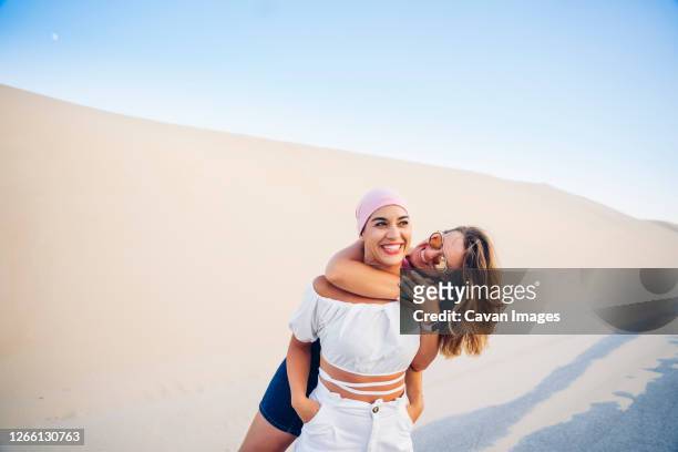 young woman with pink headscarf fighting cancer together with her friend. - best bosom stock-fotos und bilder