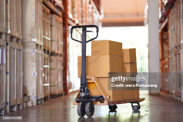hand pallet truck carrying empty cardboard box in warehouse distribution - diable-chariots-et-charrettes photos et images de collection