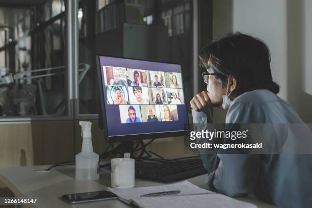 trabajador solitario que asiste a una reunión de videoconferencia grupal en la oficina, con colegas de equipo remoto - real businessman isolated no smile fotografías e imágenes de stock