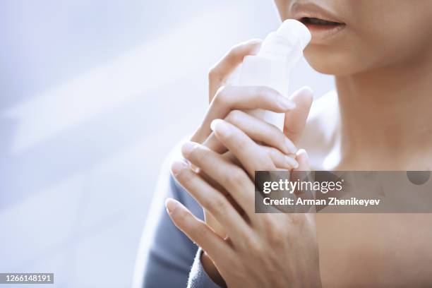 woman using inhaler - mouth spray stock pictures, royalty-free photos & images