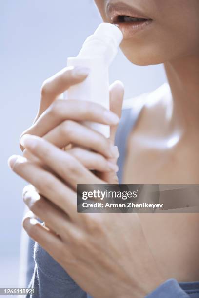 woman using inhaler - mouth spray stock pictures, royalty-free photos & images