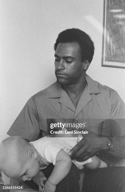 Huey P. Newton, was an African-American political activist who co-founded the Black Panther Party. Photographed holding a baby, in Berkeley,...