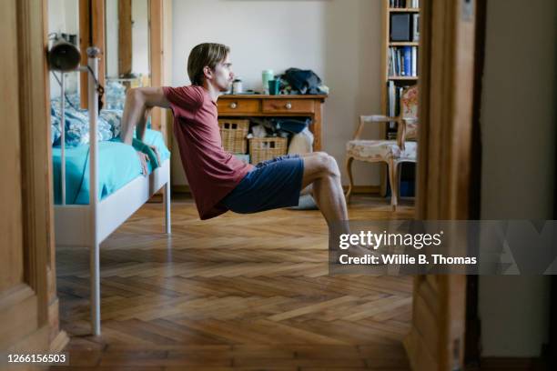 young man doing body weight exercises at home - real body fotografías e imágenes de stock