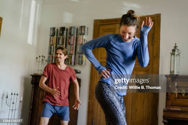 couple having fun working out at home together - home workout stockfoto's en -beelden