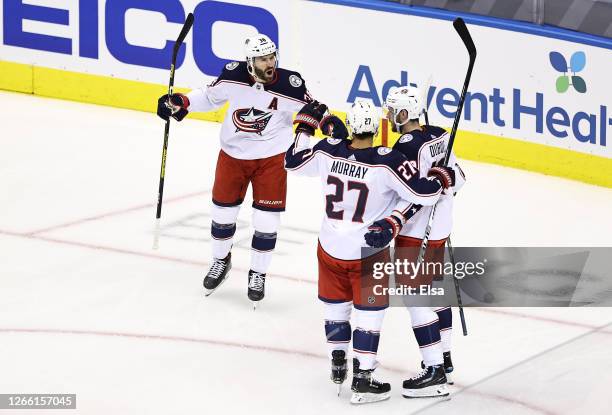 Ryan Murray of the Columbus Blue Jackets is congratulated by his teammates, Boone Jenner and Pierre-Luc Dubois after scoring a goal against the Tampa...