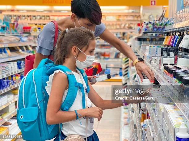 mother and daughter in protective face mask back to school shopping during covid-19 pandemic - stock photo - artist tools stock pictures, royalty-free photos & images