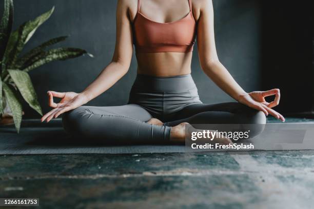anonymous woman doing yoga at home: lotus position - ioga imagens e fotografias de stock