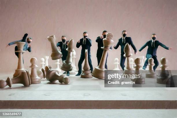 businessmen hitting chess figures - assertiveness stock pictures, royalty-free photos & images