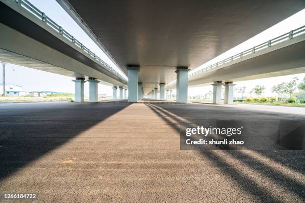 asphalt road under the viaduct - viaduct ストックフォトと画像