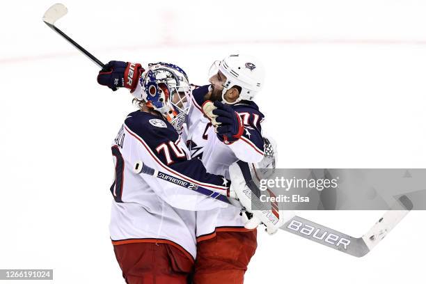 Joonas Korpisalo and Nick Foligno of the Columbus Blue Jackets celebrate their teams 3-1 win against the Tampa Bay Lightning in Game Two of the...