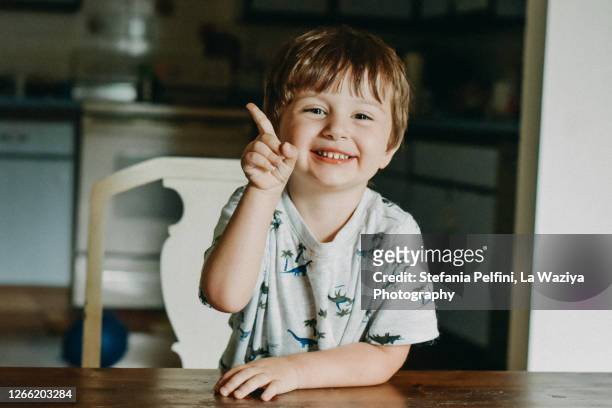 portrait of a smiling toddler while raising his index finger - demander photos et images de collection