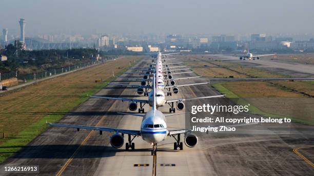 a large number of aircraft sliding in a line for take off in chengdu shuangliu international airport，sichuan，china - airport traffic stockfoto's en -beelden
