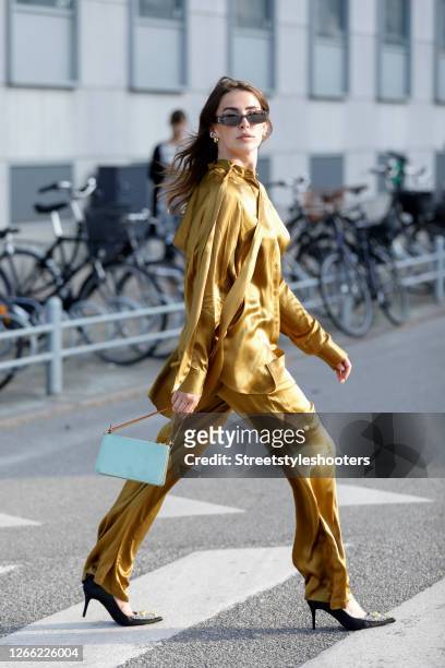 Influencer Sarah Lou Falk, wearing a golden suit by Lala Berlin, heels by Custommade, a mint colored bag by Louis Vuitton and sunglasses by Gucci...